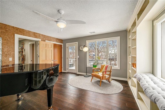 sitting room featuring visible vents, dark wood-type flooring, a ceiling fan, a textured ceiling, and baseboards