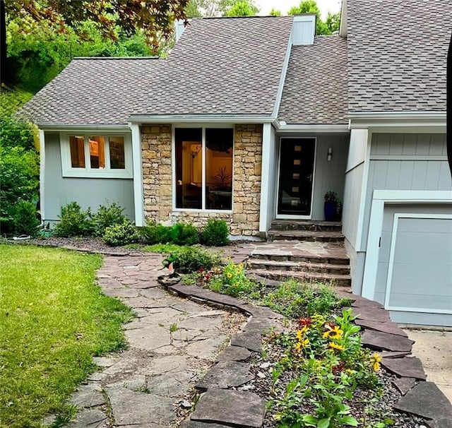 entrance to property featuring a shingled roof, stone siding, and board and batten siding