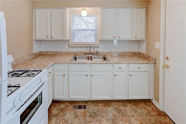 kitchen with white cabinetry, sink, and white gas stove