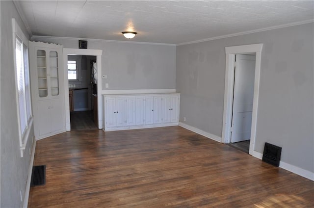 spare room featuring crown molding and dark wood-type flooring