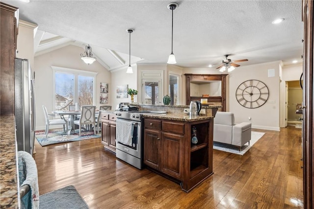 kitchen featuring stainless steel appliances, dark brown cabinets, light stone countertops, dark wood-style floors, and decorative light fixtures