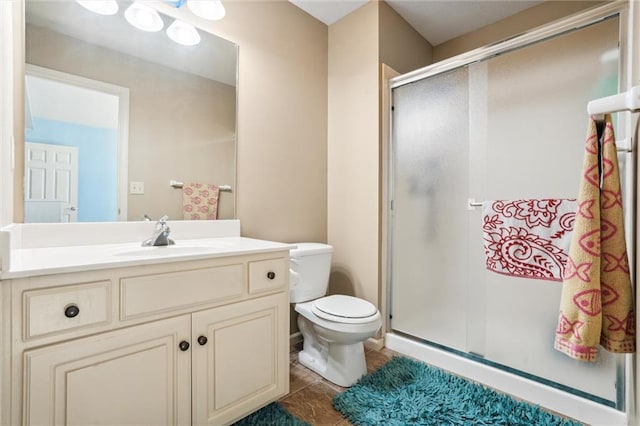 bathroom featuring toilet, vanity, and a shower stall