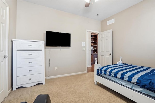 bedroom featuring a ceiling fan, light colored carpet, visible vents, and baseboards