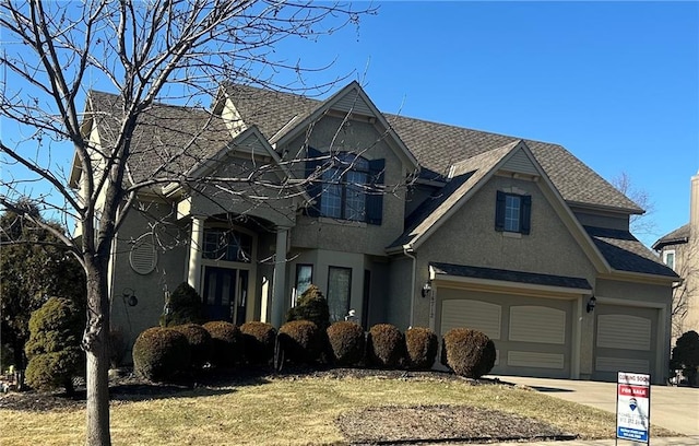 view of front of home with concrete driveway, a shingled roof, a balcony, and stucco siding