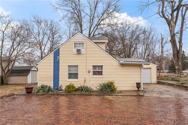 view of property exterior featuring a garage and a storage unit