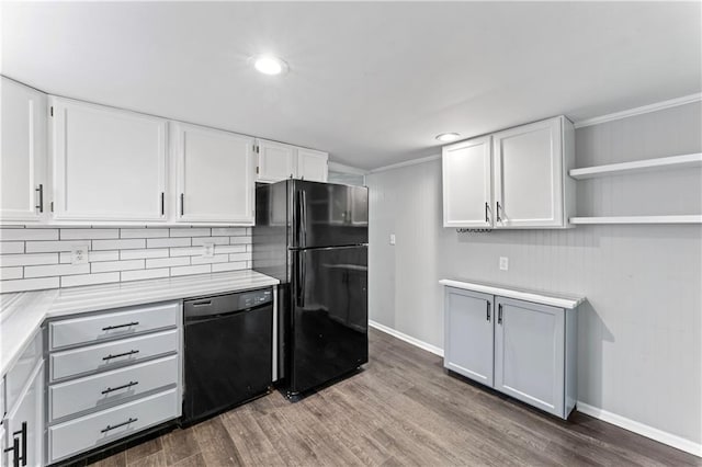 kitchen with tasteful backsplash, white cabinets, hardwood / wood-style floors, and black appliances