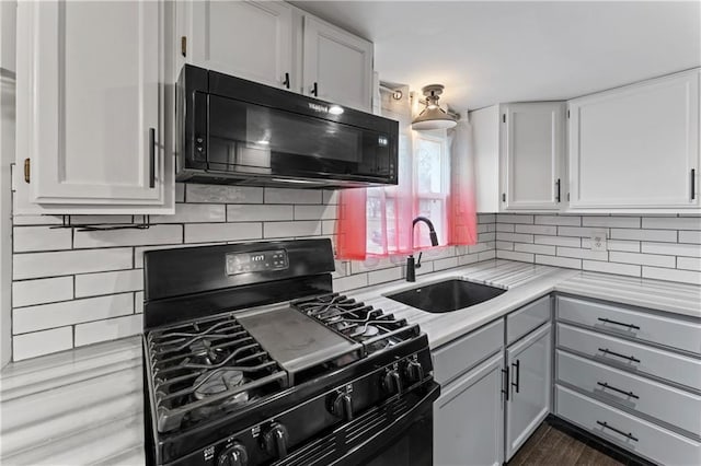 kitchen featuring sink, white cabinets, backsplash, and black appliances