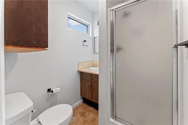 bathroom with tile patterned flooring, vanity, a shower with door, and toilet