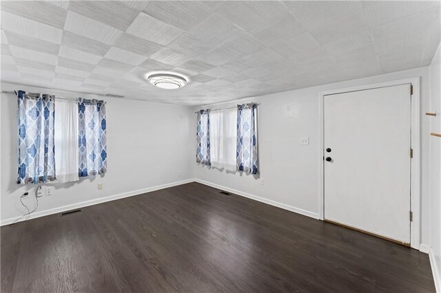 interior space featuring baseboards, dark wood-style flooring, and visible vents