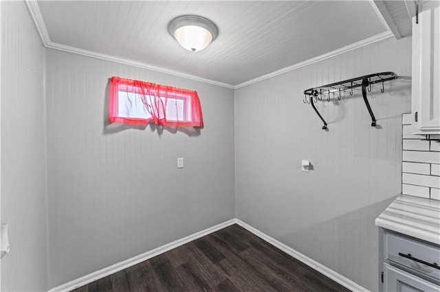 laundry room featuring crown molding, baseboards, and dark wood-style floors