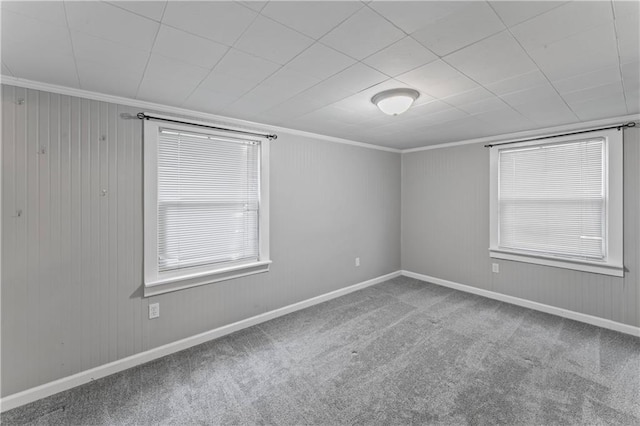carpeted empty room featuring baseboards and ornamental molding