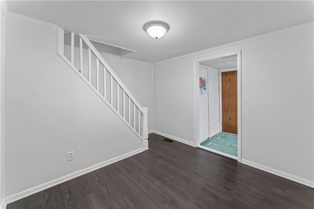 foyer with crown molding, baseboards, wood finished floors, visible vents, and stairway