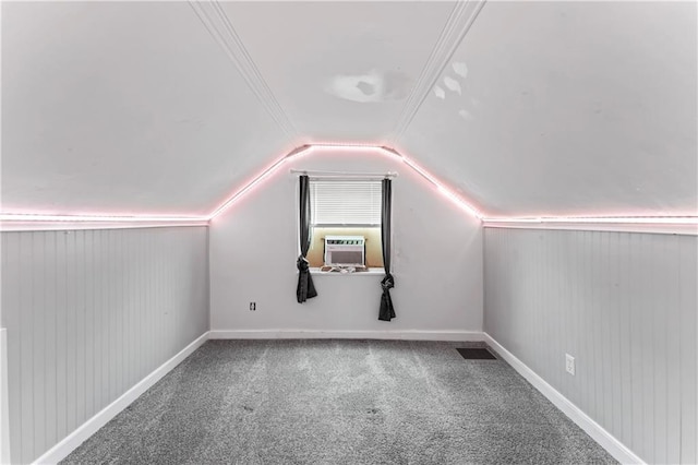 bonus room with carpet flooring, wooden walls, visible vents, cooling unit, and vaulted ceiling