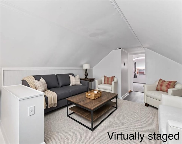 living area with wood finished floors, arched walkways, and lofted ceiling
