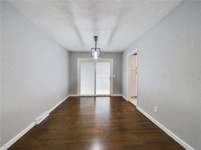 interior space with dark hardwood / wood-style floors and a textured ceiling