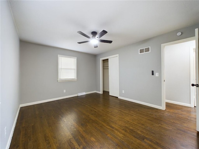 unfurnished bedroom with ceiling fan, dark hardwood / wood-style flooring, and a closet