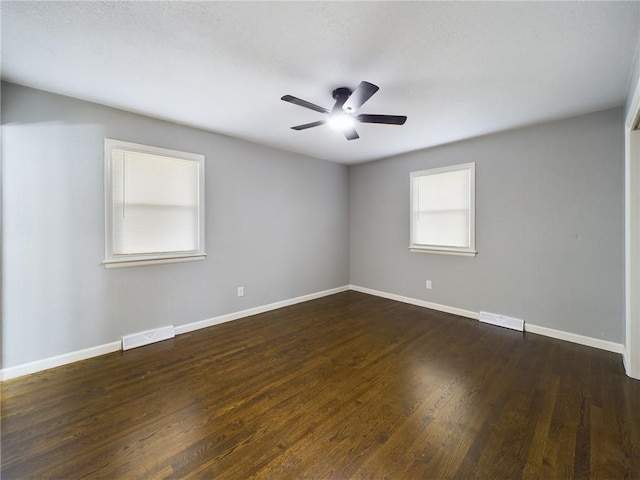 spare room with dark hardwood / wood-style floors and ceiling fan