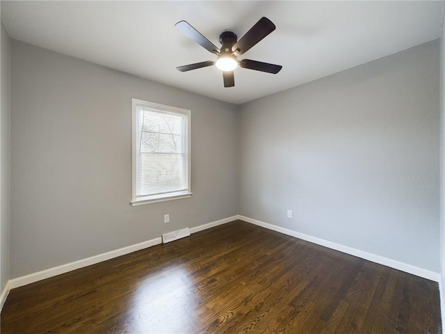 spare room with dark wood-type flooring and ceiling fan