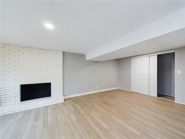 basement featuring a fireplace and light hardwood / wood-style floors