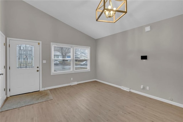 entrance foyer featuring vaulted ceiling, a chandelier, and light wood-type flooring