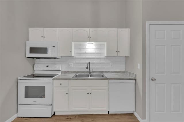 kitchen with white cabinetry, white appliances, sink, and tasteful backsplash