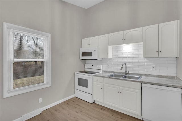 kitchen featuring tasteful backsplash, white cabinetry, sink, white appliances, and light hardwood / wood-style flooring