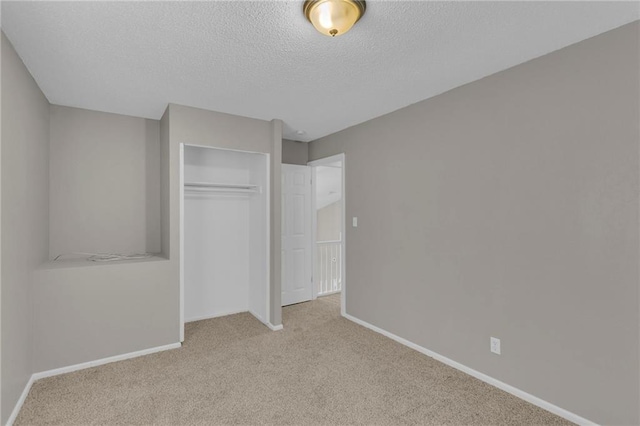 unfurnished bedroom with a closet, light carpet, and a textured ceiling