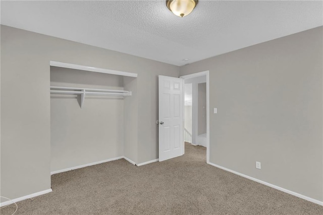 unfurnished bedroom featuring carpet floors, a closet, and a textured ceiling