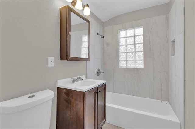 full bathroom featuring vanity, tiled shower / bath combo, lofted ceiling, and toilet