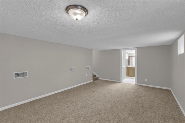 empty room featuring carpet flooring and a textured ceiling