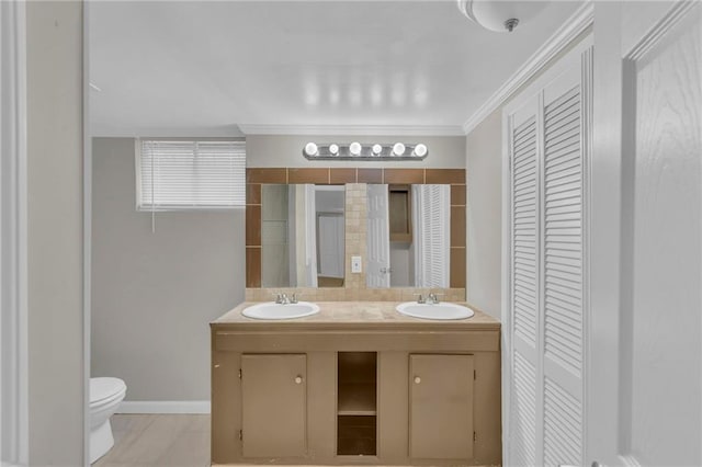 bathroom with vanity, crown molding, and toilet