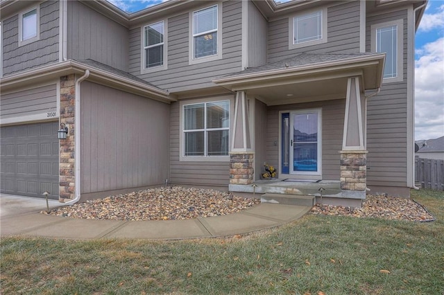 view of front of home with a garage, stone siding, and a lawn