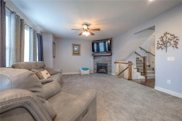 living area featuring baseboards, carpet flooring, and a glass covered fireplace