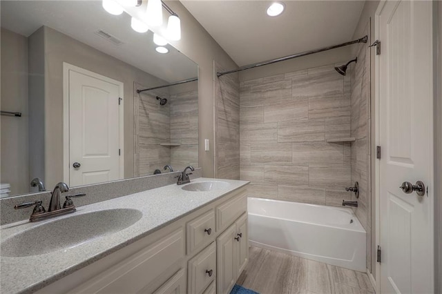 full bathroom with shower / bath combination, visible vents, a sink, and double vanity