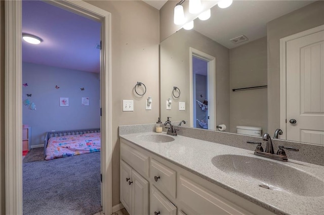 full bathroom with visible vents, a sink, toilet, and double vanity