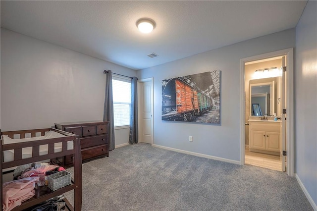 bedroom featuring visible vents, connected bathroom, baseboards, and carpet flooring