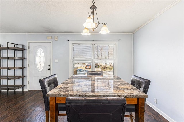 dining area featuring dark wood finished floors, a textured ceiling, baseboards, and ornamental molding