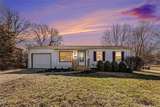 view of front facade featuring an attached garage, board and batten siding, driveway, and a yard