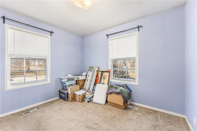 interior space featuring plenty of natural light, baseboards, and visible vents