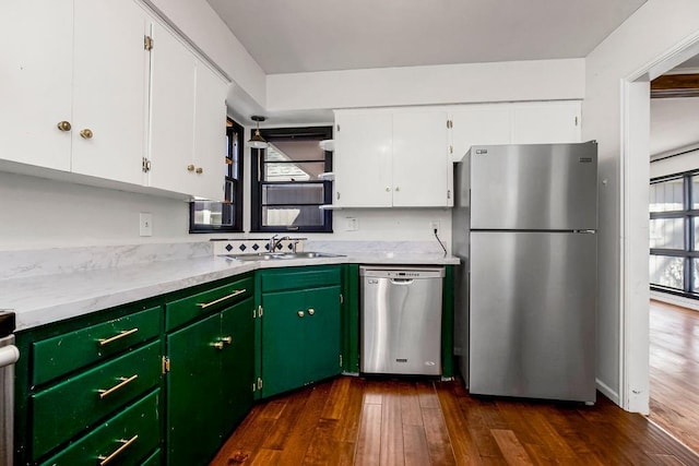 kitchen with a sink, white cabinets, light countertops, appliances with stainless steel finishes, and dark wood-style floors