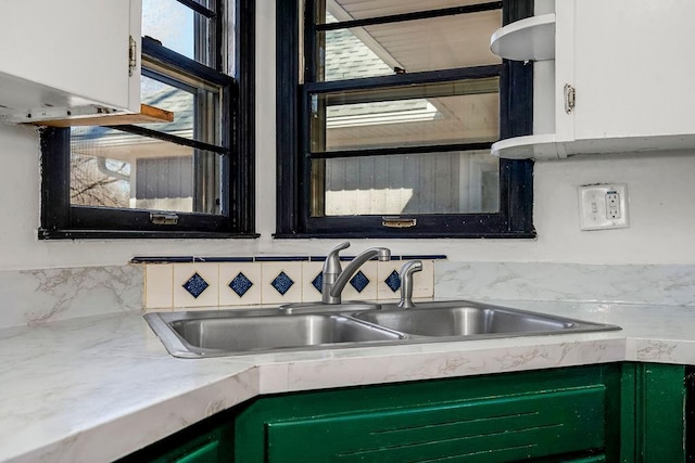 kitchen with light countertops, a sink, and white cabinets