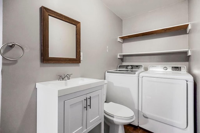 laundry room with laundry area, a sink, and separate washer and dryer