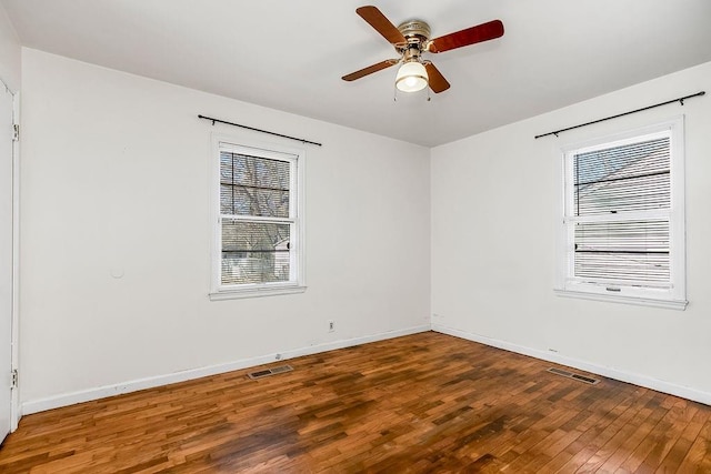 empty room with baseboards, visible vents, ceiling fan, and hardwood / wood-style floors