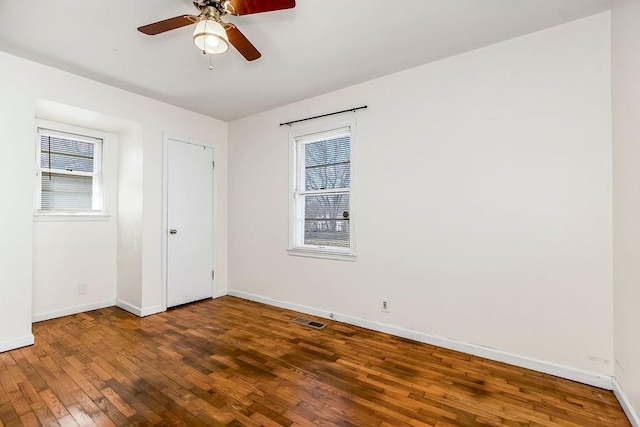 unfurnished bedroom with visible vents, ceiling fan, baseboards, and hardwood / wood-style flooring