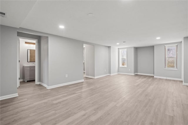 interior space with baseboards, plenty of natural light, and light wood-style floors