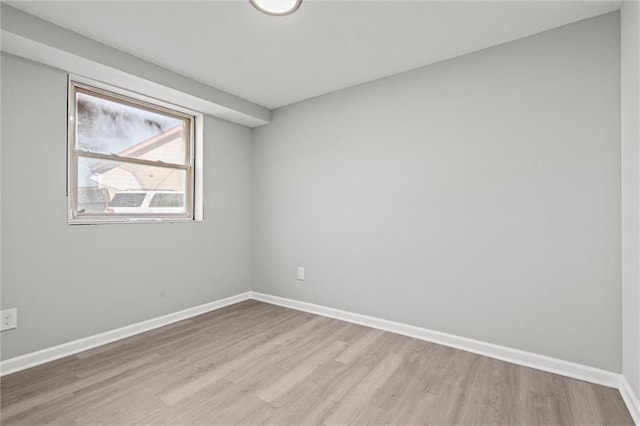 unfurnished room featuring light wood-type flooring and baseboards