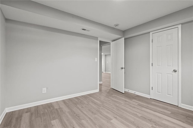 unfurnished bedroom with visible vents, baseboards, and wood finished floors