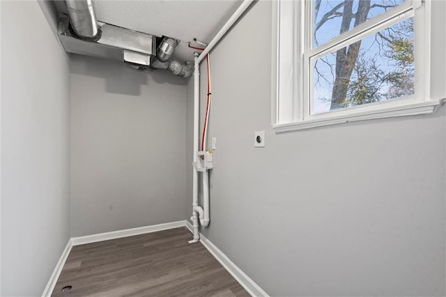 laundry room with dark wood finished floors, laundry area, baseboards, and electric dryer hookup