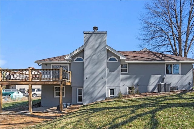 back of property with a deck, a lawn, a chimney, and stucco siding