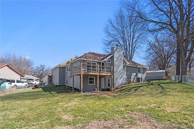 back of property featuring stucco siding, a chimney, a yard, and fence